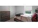 Well-lit bedroom featuring a window with blinds and a dresser with metallic hardware at 7737 Rosewood Garden Loop, Tampa, FL 33637