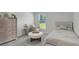 Cozy bedroom with a bed, dresser, carpet, and a window offering a view of the outdoors at 7737 Rosewood Garden Loop, Tampa, FL 33637