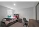 Bright bedroom featuring a window with blinds, desk, dresser and comfortable sleeping space at 7737 Rosewood Garden Loop, Tampa, FL 33637