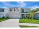 Charming two-story home with a well-manicured front yard and a gray two-car garage at 7737 Rosewood Garden Loop, Tampa, FL 33637