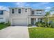 Two-story home showcasing a manicured lawn, neutral stucco, attached garage, and an inviting covered entryway at 7737 Rosewood Garden Loop, Tampa, FL 33637