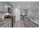 Well-lit kitchen with stainless steel appliances, gray cabinets, and granite countertops at 7737 Rosewood Garden Loop, Tampa, FL 33637