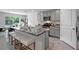 Modern kitchen features a large island with bar seating and stylish gray cabinetry at 7737 Rosewood Garden Loop, Tampa, FL 33637