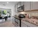 Bright kitchen with stainless steel appliances, gray cabinets, and view to the dining room at 7737 Rosewood Garden Loop, Tampa, FL 33637