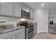 Stylish kitchen with granite countertops, gray cabinets, and stainless steel appliances at 7737 Rosewood Garden Loop, Tampa, FL 33637