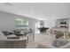 Open-concept living area with modern furniture, a dining area, and a kitchen in a neutral color scheme at 7737 Rosewood Garden Loop, Tampa, FL 33637