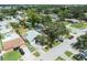An aerial view showcasing the home with a grey roof, surrounding neighborhood, and mature trees at 8233 44Th St N N St, Pinellas Park, FL 33781