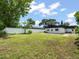 Spacious backyard enclosed with white and wood fences, a lush lawn, and mature trees at 8233 44Th St N N St, Pinellas Park, FL 33781