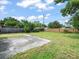Large, green backyard featuring a concrete slab, wooden fence, and some trees at 8233 44Th St N N St, Pinellas Park, FL 33781