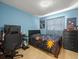 Inviting bedroom with a cozy bed, blue walls, a gaming setup, and light wood floors at 8233 44Th St N N St, Pinellas Park, FL 33781