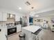 Bright kitchen features stainless steel appliances, white cabinetry, mosaic backsplash, and a large island at 8233 44Th St N N St, Pinellas Park, FL 33781