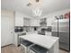 Bright kitchen features stainless steel appliances, white cabinetry, mosaic backsplash and a large quartz island at 8233 44Th St N N St, Pinellas Park, FL 33781