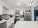Bright kitchen features stainless steel appliances, white cabinetry, mosaic backsplash, and a large quartz island at 8233 44Th St N N St, Pinellas Park, FL 33781