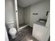 Bathroom featuring a toilet, tiled shower, granite sink counter, and wood-look tile flooring at 9053 Bourbon St, New Port Richey, FL 34654