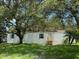 Charming home with white siding and green lawn, shaded by mature trees at 9053 Bourbon St, New Port Richey, FL 34654