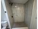Glass shower with a rainfall shower head, grey-scale marble style tile, and a hexagon tile floor at 9053 Bourbon St, New Port Richey, FL 34654
