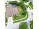 Aerial shot featuring a home with an attached garage, screened pool, and lush landscaping at 10675 Park Place Dr, Largo, FL 33778