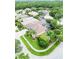 An aerial view of a landscaped property showcases its lush greenery, screened-in pool, and peaceful neighborhood setting at 10675 Park Place Dr, Largo, FL 33778