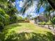 Large backyard with well-maintained lawn and a screened-in patio at 10675 Park Place Dr, Largo, FL 33778
