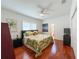 Bright bedroom with a queen-sized bed, palm-themed bedding, and wood floors at 10675 Park Place Dr, Largo, FL 33778