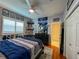 Well-decorated bedroom with Tampa Bay Rays decor, hardwood floors, shutters, and a ceiling fan at 10675 Park Place Dr, Largo, FL 33778