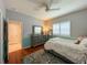 Inviting bedroom with hardwood floors, a ceiling fan, plantation shutters, and a dresser with a mirror at 10675 Park Place Dr, Largo, FL 33778