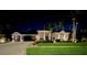Charming exterior with a lush lawn, mature trees, and a well-lit facade at night at 10675 Park Place Dr, Largo, FL 33778