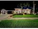 Stunning exterior showcasing manicured lawn, lush landscaping, and a well-lit home at night at 10675 Park Place Dr, Largo, FL 33778