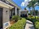 Home exterior featuring columns, an ADT security sign, and decorative shrubs and flowers at 10675 Park Place Dr, Largo, FL 33778