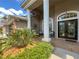 Covered front entryway featuring an elegant glass paneled door and seating area at 10675 Park Place Dr, Largo, FL 33778