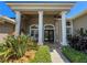 Front entryway with brick flooring, white support columns, and a pair of chairs at 10675 Park Place Dr, Largo, FL 33778