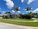 Landscaped front lawn featuring multiple palm trees and beautiful greenery at 10675 Park Place Dr, Largo, FL 33778