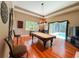 Bright game room featuring a pool table, hardwood floors, and views of the pool area at 10675 Park Place Dr, Largo, FL 33778