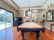 Bright game room featuring a pool table, hardwood floors, and access to the outdoor living space at 10675 Park Place Dr, Largo, FL 33778