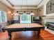 Entertaining game room with a pool table, fireplace, hardwood floors, and outdoor access at 10675 Park Place Dr, Largo, FL 33778