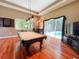 Recreation room with a pool table, hardwood floors, and sliding glass doors to the pool area at 10675 Park Place Dr, Largo, FL 33778