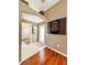 Hallway with hardwood floors leading to a bathroom with tiled floor, and dartboard at 10675 Park Place Dr, Largo, FL 33778