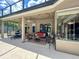 Inviting screened patio featuring outdoor seating, a ceiling fan, and decorative string lights at 10675 Park Place Dr, Largo, FL 33778