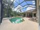 Relaxing outdoor pool area with a large screened-in lanai, spa, lounge chairs, and ample patio space at 10675 Park Place Dr, Largo, FL 33778