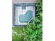 Aerial close-up of screened-in pool with patio area surrounded by lush, tropical foliage at 10675 Park Place Dr, Largo, FL 33778
