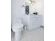 Neat bathroom featuring a white vanity, toilet, mirror, decorative lighting, and stylish mosaic tile flooring at 112 E Plymouth St, Tampa, FL 33603
