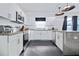 Bright, updated kitchen featuring modern stainless steel appliances, white cabinets, and granite countertops at 112 E Plymouth St, Tampa, FL 33603