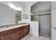 Double vanity bathroom featuring tile flooring, wood cabinets, granite countertops and a walk-in shower at 11911 Sunburst Marble Rd, Riverview, FL 33579