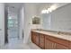 Bathroom with a double vanity and view into an en suite bedroom and walk-in closet at 11911 Sunburst Marble Rd, Riverview, FL 33579