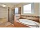 Bathroom features a walk-in shower, soaking tub, and a large window that floods the space with natural light at 11911 Sunburst Marble Rd, Riverview, FL 33579