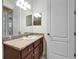 Bathroom vanity with granite countertop, sink, and mirror with vanity lighting at 11911 Sunburst Marble Rd, Riverview, FL 33579