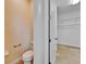 Half bathroom featuring a white toilet, neutral paint color and a view into walk-in closet at 11911 Sunburst Marble Rd, Riverview, FL 33579