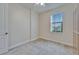 This neutral bedroom offers great light from a large window and is carpeted at 11911 Sunburst Marble Rd, Riverview, FL 33579