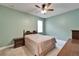 A green bedroom with a ceiling fan, large bed, nightstand, and dresser at 11911 Sunburst Marble Rd, Riverview, FL 33579