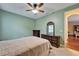 A green bedroom with a ceiling fan, large bed, dresser, and doorway at 11911 Sunburst Marble Rd, Riverview, FL 33579